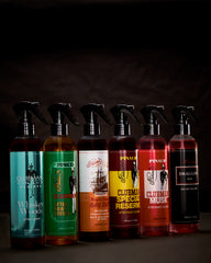 Row of Clubman Pinaud Barber Spray products on a dark background