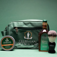 Clubman Pinaud shaving kit with aftershave, shave brush, shave soap, and a branded green dopp bag.